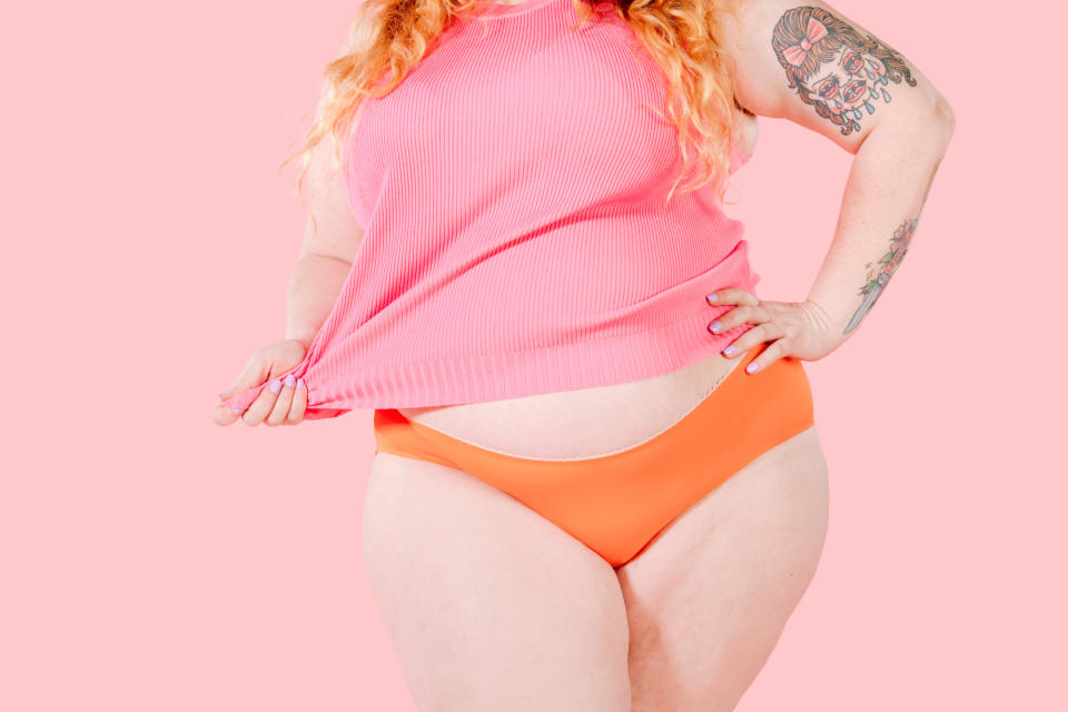 Woman in Mid Waisted coral undies and pink singlet