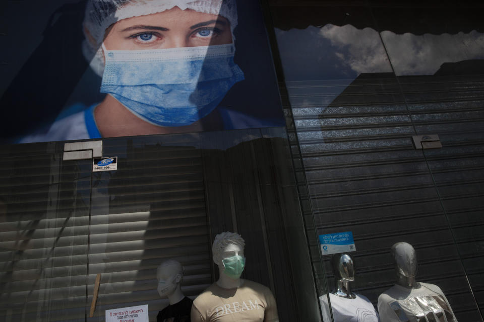 A shop selling face masks displays them on mannequins in their shop window, amid concerns over the country's coronavirus outbreak, during Israel's 72nd Independence Day, in Tel Aviv, Israel, Wednesday, April 29, 2020. Israel government announced a complete lockdown over the Independence Day to control the country's coronavirus outbreak. (AP Photo/Oded Balilty)