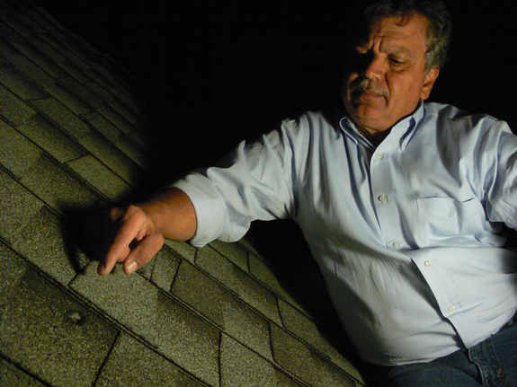 The dent in a roof caused by a meteorite from the Oct. 17, 2012, fireball over Northern California is identified by Luis Rivera, the neighbor of Lisa Webber who found the meteorite after it struck her Novata, Calif., home.