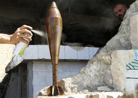 A Free Syrian Army fighter spray paints an improvised mortar shell, as his fellow fighter watches him, in Aleppo September 4, 2013. REUTERS/Hamid Khatib