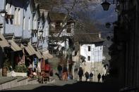 People walk in Gjirokastra town, southern Albania, Friday, Feb. 5, 2021. Tourism had been flourishing in the UNESCO-protected city of Gjirokastra but the coronavirus pandemic brought an abrupt halt to that, with the prospects still bleak in 2021, and now residents are calling for government help to keep their businesses afloat. (AP Photo/Hektor Pustina)