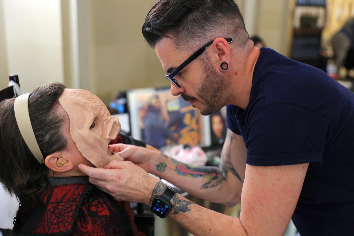Special effects makeup artist Nathan Bright places a mask on Sheri Wise during Film and Music Day at the Capitol in Oklahoma City, Monday, March 25, 2024.
