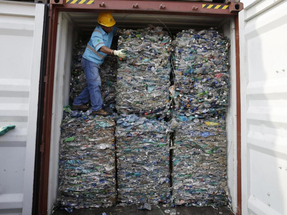 A worker stands inside a container full of plastic waste at Tanjung Priok port in Jakarta, Indonesia: AP Photo/Achmad Ibrahim