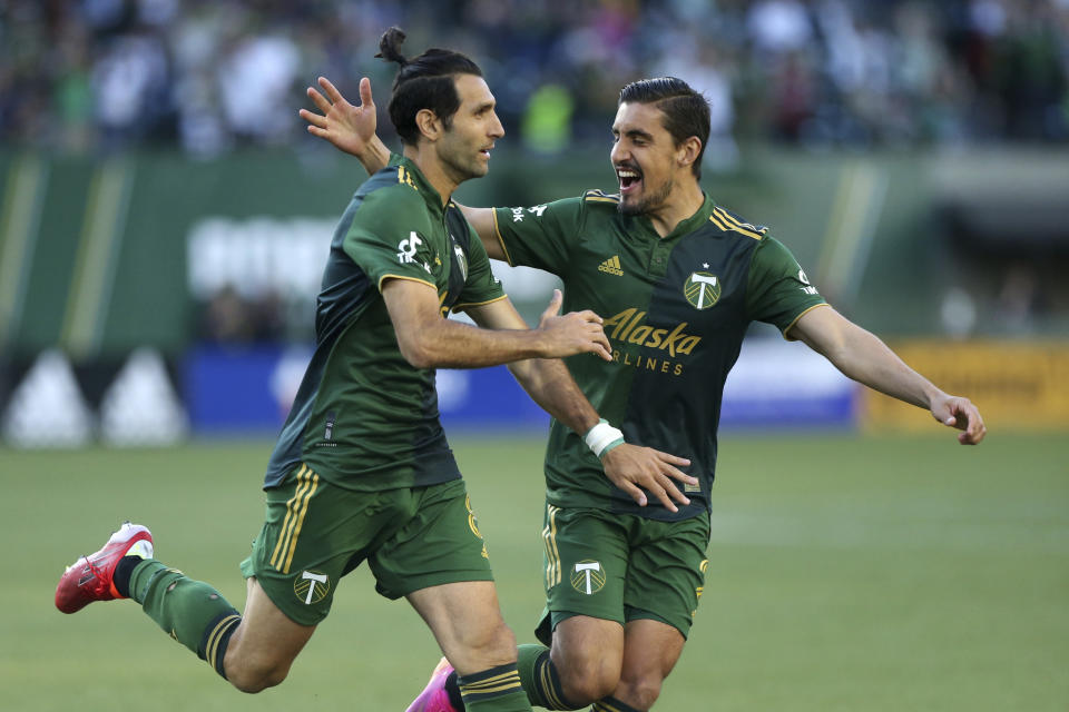 Portland Timbers midfielder Diego Valeri, left, and defender Josecarlos Van Rankin celebrate after Valeri scores his 100th MLS goal, against Los Angeles FC during the first half of an MLS soccer match Wednesday, July 21, 2021, in Portland, Ore. (Sean Meagher/The Oregonian via AP)