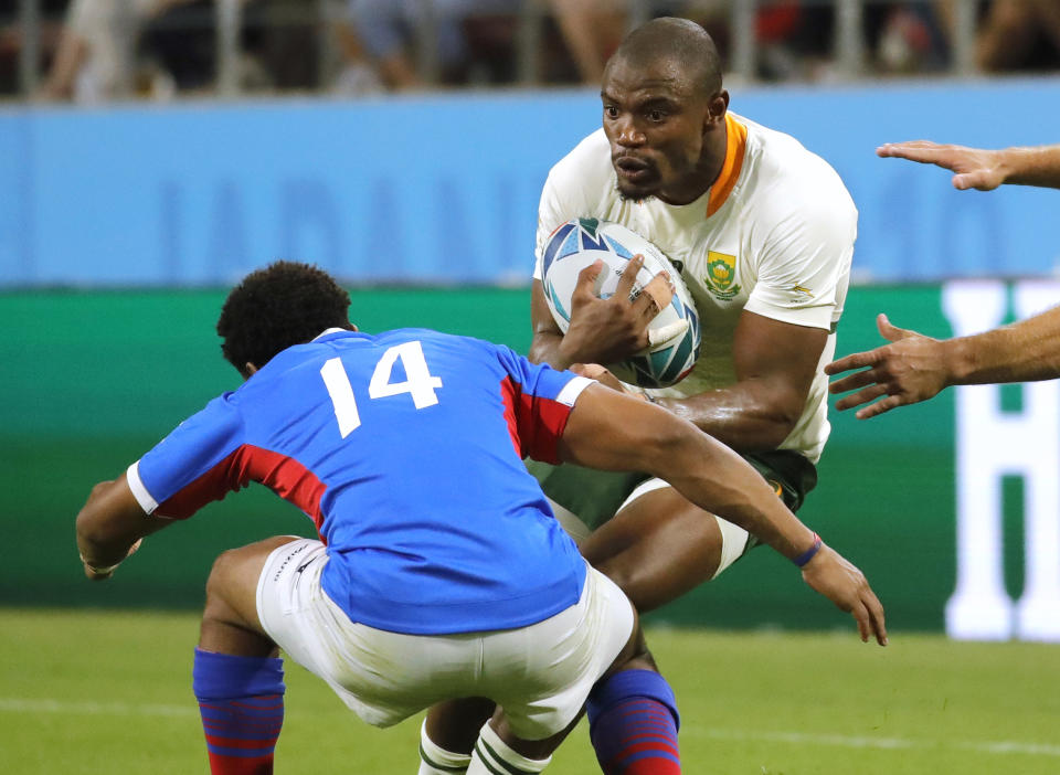 South Africa's Makazole Mapimpi runs at the Namibia's Chad Plato, left, during the Rugby World Cup Pool B game at the City of Toyota Stadium between South Africa and Namibia in Toyota City, Japan, Saturday, Sept. 28, 2019. (AP Photo/Christophe Ena)