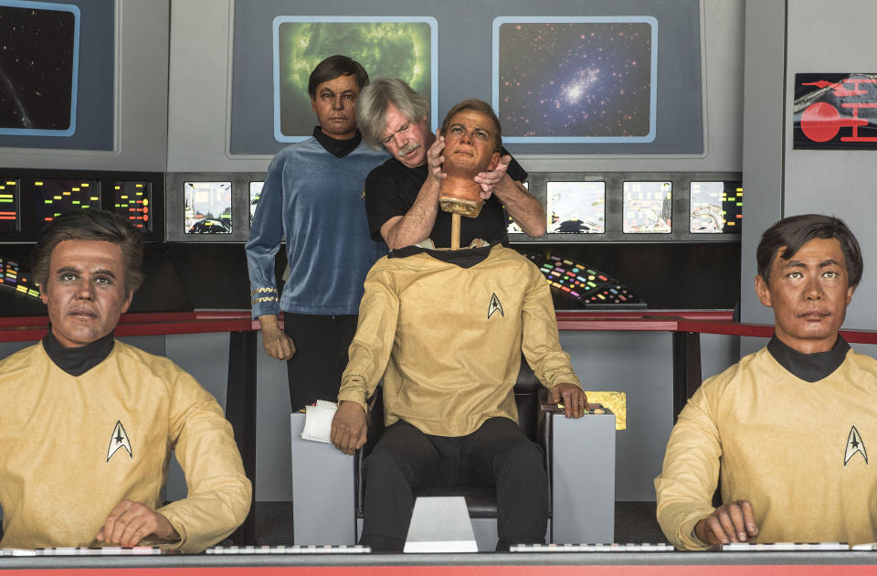 In this Saturday, March 25, 2017 photo, Steve Greenthal puts on the head of his Captain Kirk wax figure at the Fullerton Airport before donating them to the Hollywood Science Fiction Museum in Fullerton, Calif. The figures were purchased when the Movieland Wax Museum in Buena Park went out of business. The figures are being restored for a five-year tour to raise money to get the museum a permanent home. (Nick Agro/The Orange County Register via AP)