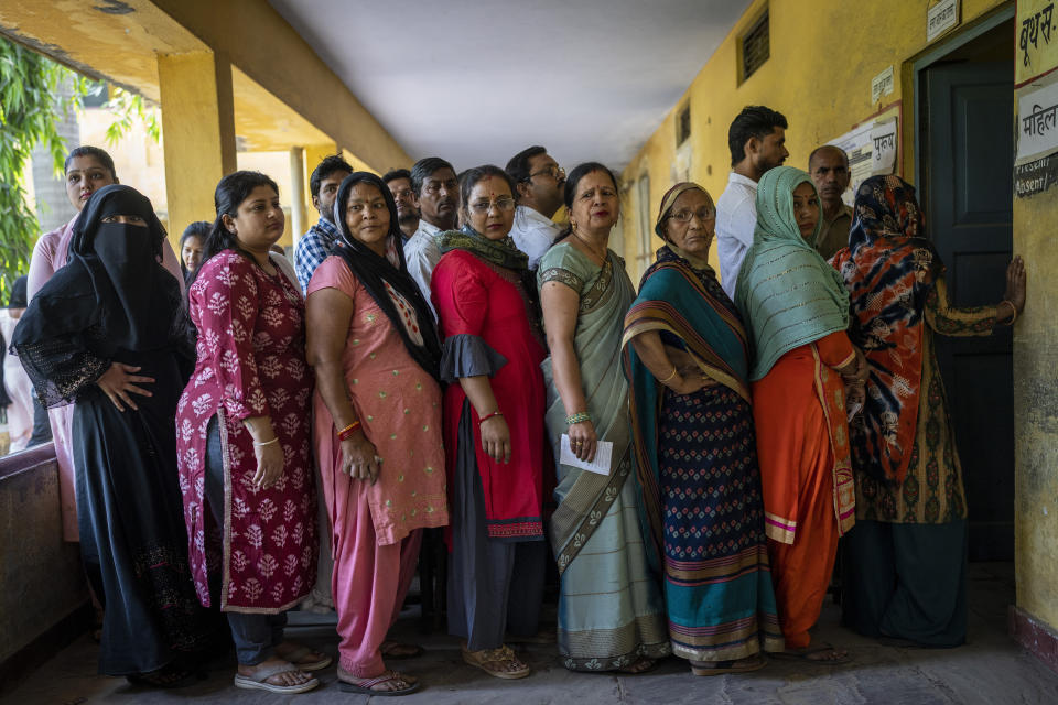 People stand in a queue to vote during the second round of voting in the six-week-long national election in Nahal village near Meerut, in Uttar Pradesh, India, Friday, April 26, 2024. (AP Photo/Altaf Qadri)