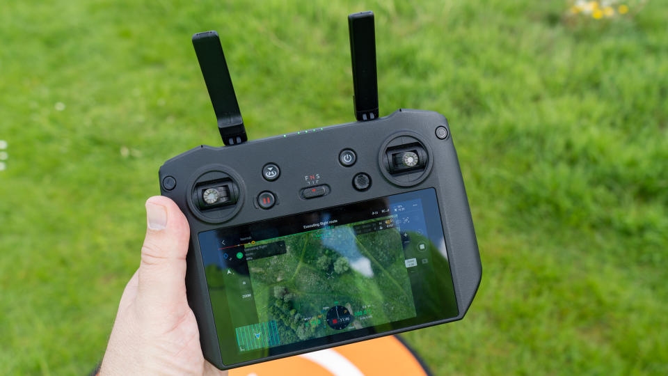 DJI Mavic 3T Pro RC controller in hand with grass behind