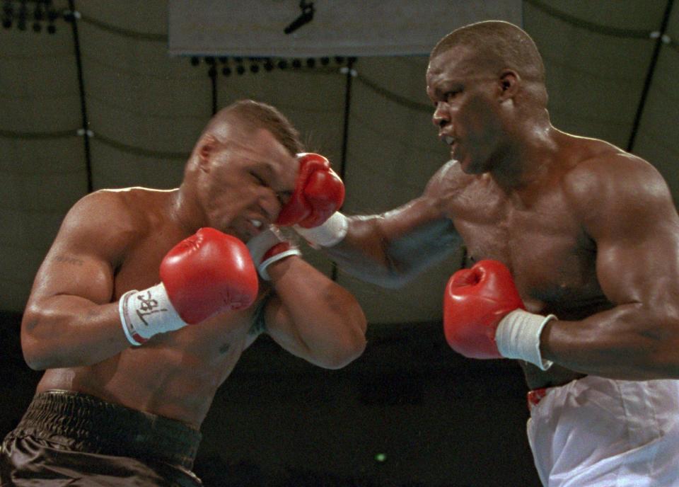 In this Feb. 11, 1990, file photo, James "Buster" Douglas, right, hits Mike Tyson with a hard right in the face during their world heavyweight title bout at the Tokyo Dome in Tokyo.