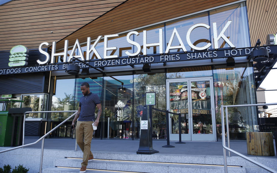 FILE - In this April 15, 2015, file photo, a man walks out of a Shake Shack in front of the New York-New York hotel and casino in Las Vegas. Shake Shack reports financial results Monday, Feb. 25, 2019. (AP Photo/John Locher, File)