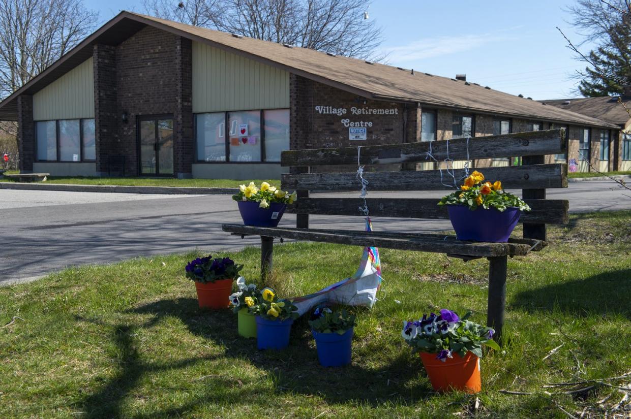 <span class="caption">Flowers sit on a bench in front of a for-profit long-term care home in Pickering, Ont., where dozen of seniors died of COVID-19, in April 2020. </span> <span class="attribution"><span class="source">THE CANADIAN PRESS/Frank Gunn</span></span>