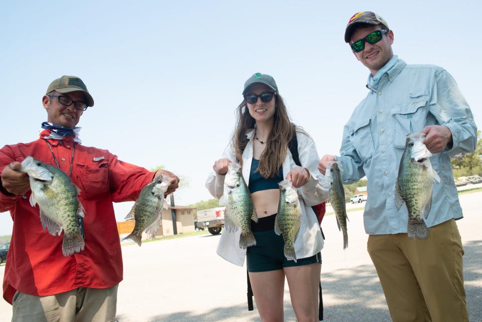 Six crappie are held by Joe Bragg, from left, Sophia Jackel and Duncan MacLachian on Tuesday at Milford Lake. Bragg took the students from the Kansas City area on a short fishing trip. They caught more than a dozen.