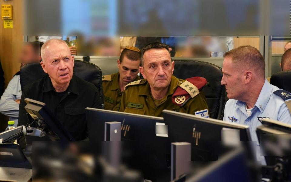 Israeli Defense Minister Yoav Gallant (L) is joined by military officers as they watch strikes on Beirut