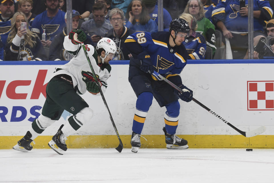 St. Louis Blues' Pavel Buchnevich (89) works the puck against Minnesota Wild's Mats Zuccarello (36) during the first period in Game 4 of an NHL hockey Stanley Cup first-round playoff series on Sunday, May 8, 2022, in St. Louis. (AP Photo/Michael Thomas)