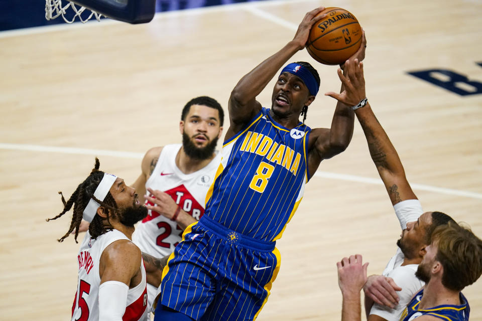 Indiana Pacers guard Justin Holiday (8) shoots over Toronto Raptors forward DeAndre' Bembry (95) during the first half of an NBA basketball game in Indianapolis, Sunday, Jan. 24, 2021. (AP Photo/Michael Conroy)