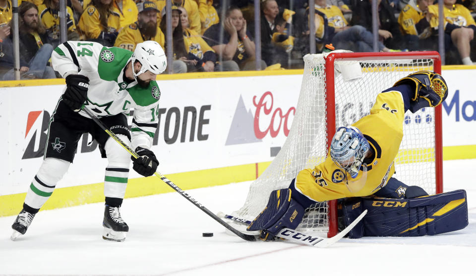 Dallas Stars left wing Jamie Benn (14) and Nashville Predators goaltender Pekka Rinne (35), of Finland, reach for the puck during the third period in Game 2 of an NHL hockey first-round playoff series Saturday, April 13, 2019, in Nashville, Tenn. (AP Photo/Mark Humphrey)