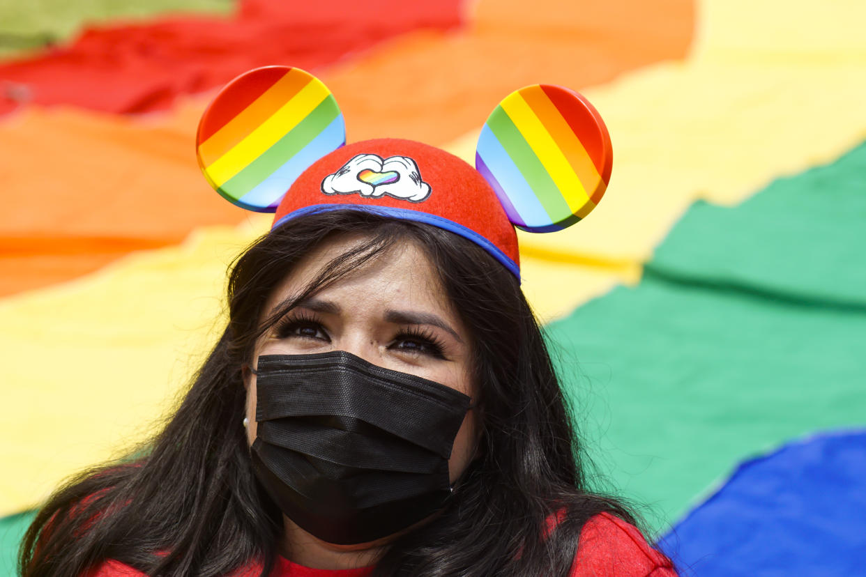 A woman wears Mickey Mouse ears with the Pride colors during a LGBT community Pride parade on June 26, 2021 in San Salvador, El Salvador. (Photo by APHOTOGRAFIA/Getty Images)