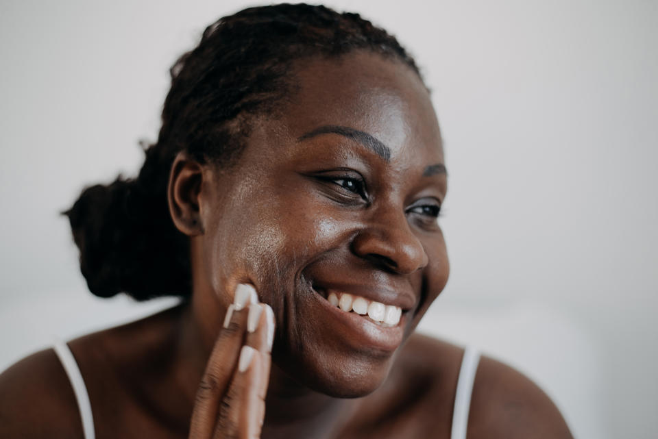 Woman smiling and touching her face