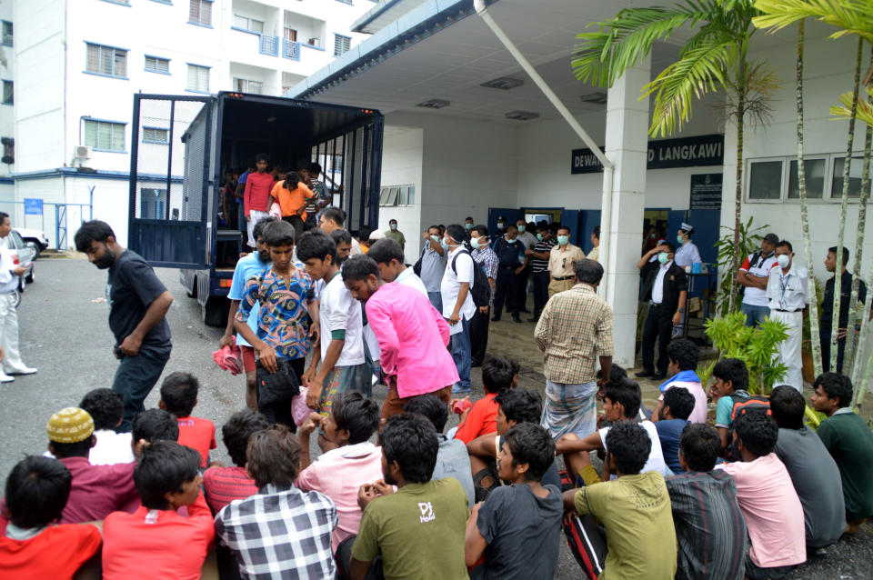 Migrants from Myanmar and Bangladesh arrive at the Langkawi police station's multi purpose hall in Langkawi, Malaysia on Monday, May 11, 2015. (AP Photo/Hamzah Osman)