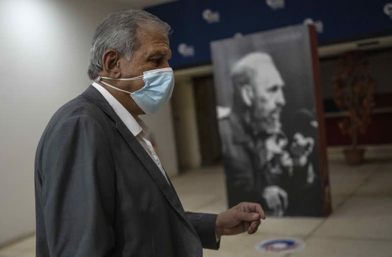 Mitchell Joseph Valdés-Sosa, director del Centro de Neurociencias de Cuba, pasa junto a una foto de Fidel Castro antes de una conferencia de prensa sobre los síntomas reportados por diplomáticos estadounidenses y canadienses en 2016 y 2017, comúnmente conocido como el "Síndrome de La Habana", en La Habana, Cuba, lunes 13 de septiembre de 2021. (AP Foto/ Ramón Espinosa)