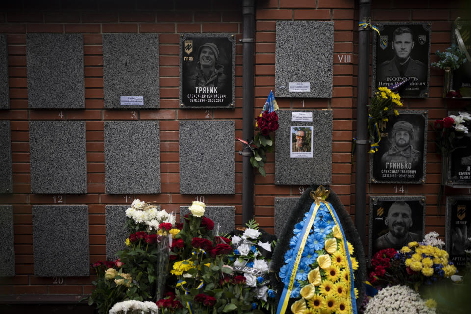 Flowers are placed in front of the grave of Ukrainian soldier Oleksandr Hrianyk in Kyiv, Ukraine, Saturday, Oct. 28, 2023. Hrianyk died in battle in May 2022 in the city of Mariupol, but was only cremated recently after his remains were found and identified. (AP Photo/Bram Janssen)