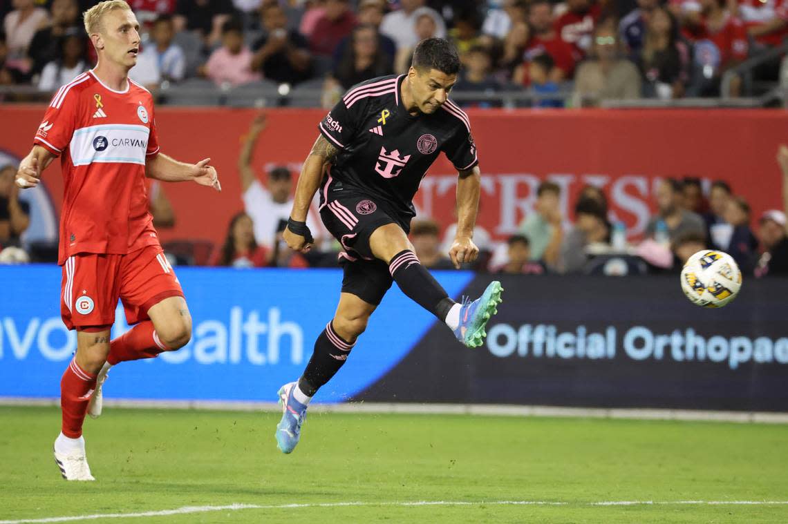 Aug 31, 2024; Chicago, Illinois, USA; Inter Miami CF forward Luis Suarez (9) shoots and scores a goal against Chicago Fire FC defender Tobias Salquist (14) in the second half at Soldier Field. Mandatory Credit: Mike Dinovo-USA TODAY Sports