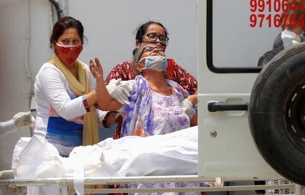 A woman mourns after seeing the body of her son who died due to the coronavirus disease, outside a mortuary of a COVID-19 hospital in New Delhi on May 12.