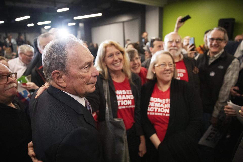 Democratic presidential candidate and former New York City Mayor Michael Bloomberg, left, has a photo taken with members of Moms Demand Action for Gun Sense in America at a campaign event Wednesday, Feb. 5, 2020, in Providence, R.I. (AP Photo/David Goldman)