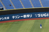 A stadium crew member, upper left, installs a device to detect carbon dioxide in the seats of a baseball stadium, home for the Yokohama DeNA BayStars, in Yokohama, south of Tokyo on Friday, Oct. 30, 2020. The device was introduced during a media tour before a Japanese professional baseball league game between the Hanshin Tigers and the DeNA BayStars on Friday. (AP Photo/Hiro Komae)