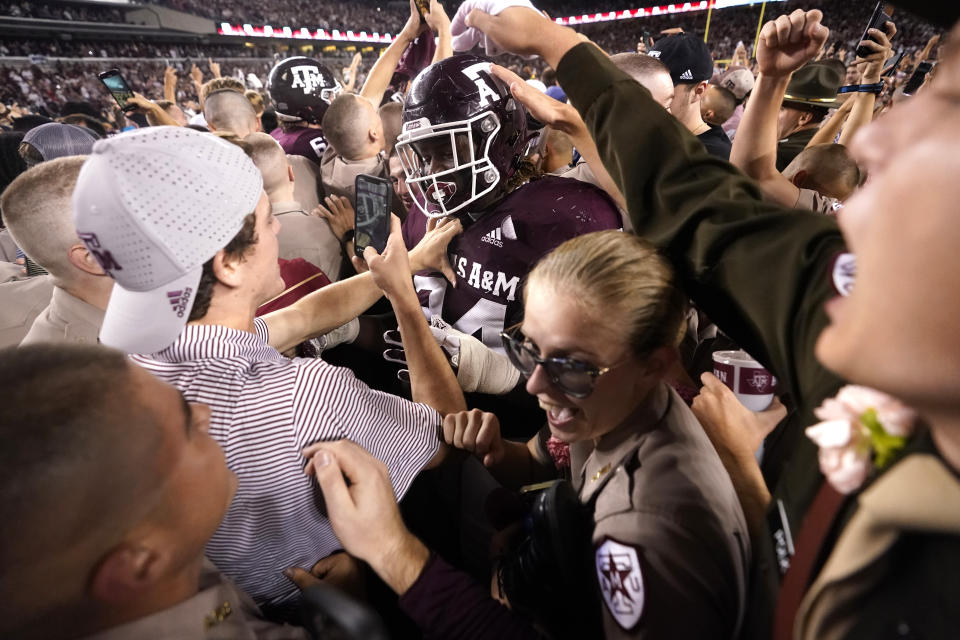 FILE - Texas A&M students celebrate with Texas A&M defensive lineman Isaiah Raikes (34) as they packed Kyle Field after upsetting Alabama 38-41 in an NCAA college football game on Oct. 9, 2021, in College Station, Texas. The “Beef Bowl,” which draws from comments Aggies coach Jimbo Fisher and Crimson Tide coach Nick Saban made about each other over concerns about NIL after Fisher brought in one of the top recruiting classes in history. (AP Photo/Sam Craft, File)