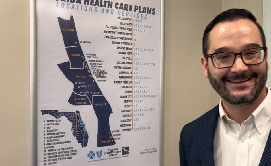 Dr. Stephen Keen stands next to a map showing Florida Health Care Plans' various locations in the five counties it serves: Volusia, Flagler, Brevard, St. Johns and Seminole, on Monday, Dec. 11, 2023. He is set to become the Daytona Beach-based HMO's new CEO on Jan. 1, 2024.