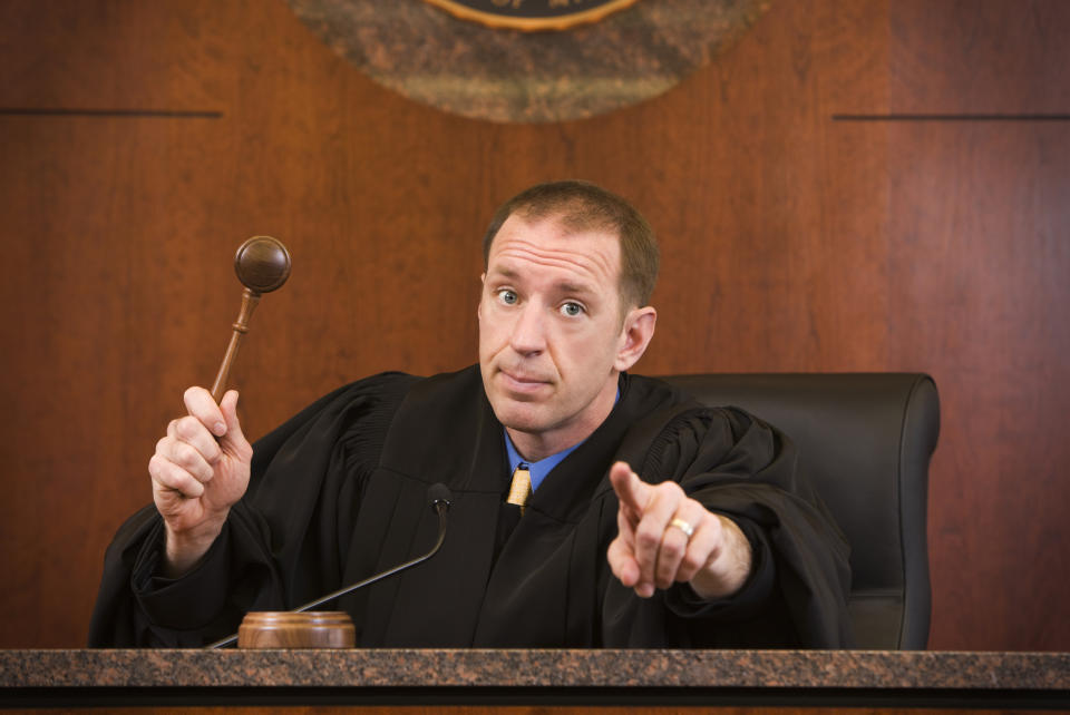 a judge pointing as he's about to bang his gavel