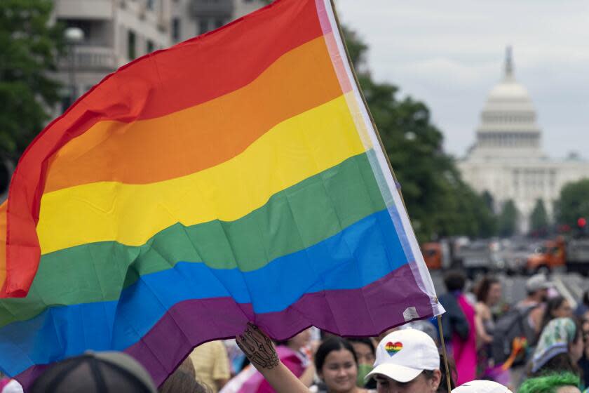 FILE - With the U.S. Capitol in the background, a person waves a rainbow flag as they participant in a rally in support of the LGBTQIA+ community at Freedom Plaza, Saturday, June 12, 2021, in Washington. The U.S. House overwhelmingly approved legislation Tuesday, July, 19, 2022, to protect same-sex and interracial marriages amid concerns that the Supreme Court ruling overturning Roe v. Wade abortion access could jeopardize other rights criticized by many conservative Americans. (AP Photo/Jose Luis Magana, File)