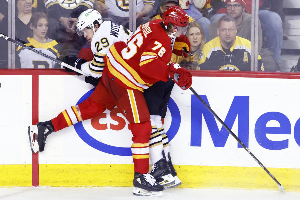 Boston Bruins' Parker Wotherspoon, left, is hit by Calgary Flames' Martin Pospisil during the third period of an NHL hockey game Thursday, Feb. 22, 2024, in Calgary, Alberta. (Larry MacDougal/The Canadian Press via AP)