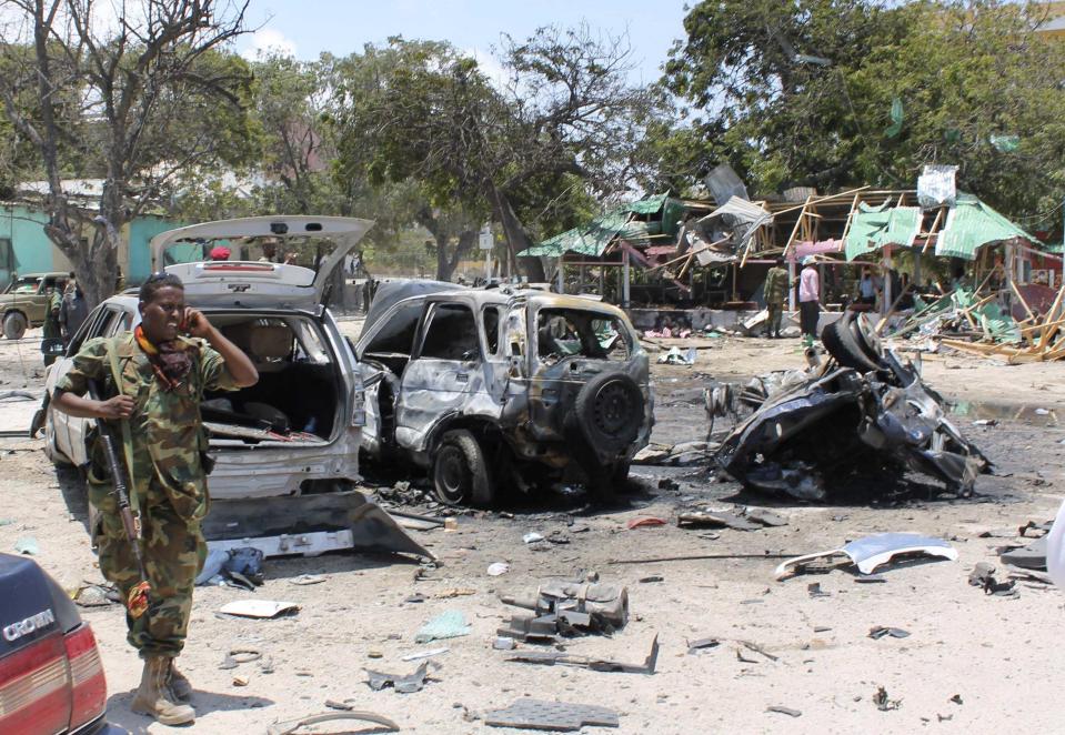 A Somali soldier walks past destroyed vehicles at the scene of a suicide car bombing near a restaurant in Hamaerweyne district in Mogadishu September 7, 2013. A car bomb and suspected suicide bomber struck the restaurant in the Somali capital Mogadishu on Saturday, killing at least 15 people, police said. (REUTERS/Feisal Omar)