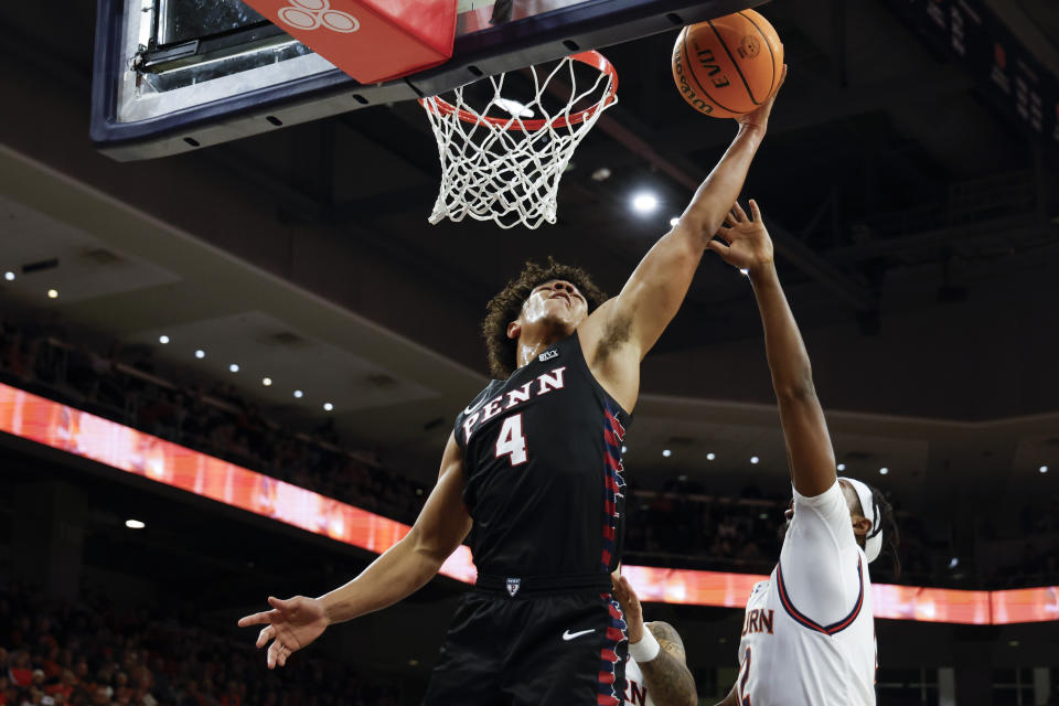 Penn guard Tyler Perkins (4) lays in a basket as Auburn forward Jaylin Williams (2) defends during the first half of an NCAA college basketball game Tuesday, Jan. 2, 2024, in Auburn, Ala.. (AP Photo/Butch Dill)