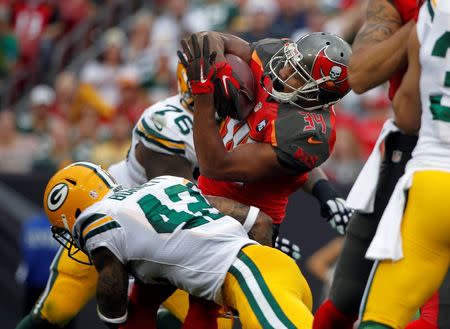 Dec 21, 2014; Tampa, FL, USA; Green Bay Packers strong safety Morgan Burnett (42) tackles Tampa Bay Buccaneers running back Charles Sims (34) during the first half at Raymond James Stadium. Mandatory Credit: Kim Klement-USA TODAY Sports