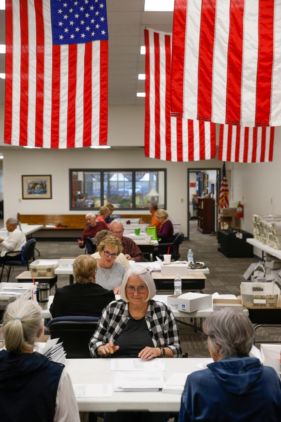 Volunteers chat at their respective tables while preparing voting registration cards to be mailed to residents at the Montgomery County Elections Commission in Clarksville, Tenn., on Thursday, March 10, 2022. 