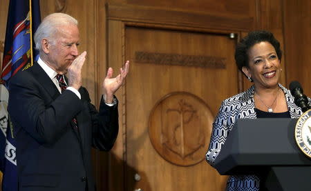 Loretta Lynch (R) smiles after being sworn in as the 83rd U.S. Attorney General, and the first black woman to occupy the post, by Vice-President Joe Biden (L) at the Justice Department in Washington April 27, 2015. REUTERS/Gary Cameron