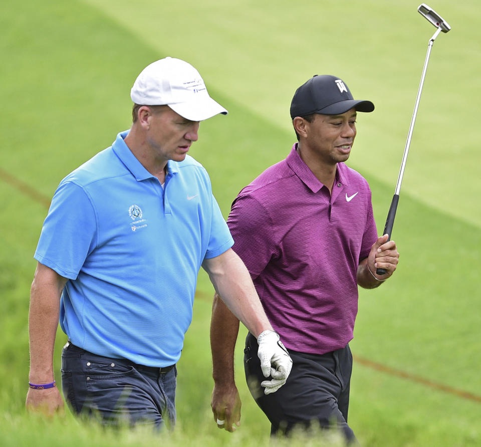 Peyton Manning, left, and Tiger Woods will team up and face Tom Brady and Phil Mickelson on Sunday in The Match: Champions for Charity. (AP Photo/David Dermer)