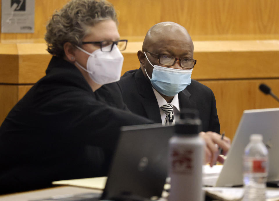 Billy Chemirmir, right, listens to private investigator Tonia Silva as his murder trial gets underway at the Frank Crowley Courts Building in Dallas, Monday, Nov. 15, 2021. Chemirmir is charged with killing 18 older women in Dallas and its suburbs over a two-year span. (Tom Fox/The Dallas Morning News via AP, Pool)