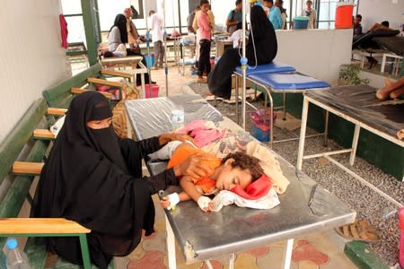 A girl, cholera patient, lies on a bed as she receives medical care at a health center in the village of Islim, in the northwestern province of Hajjah