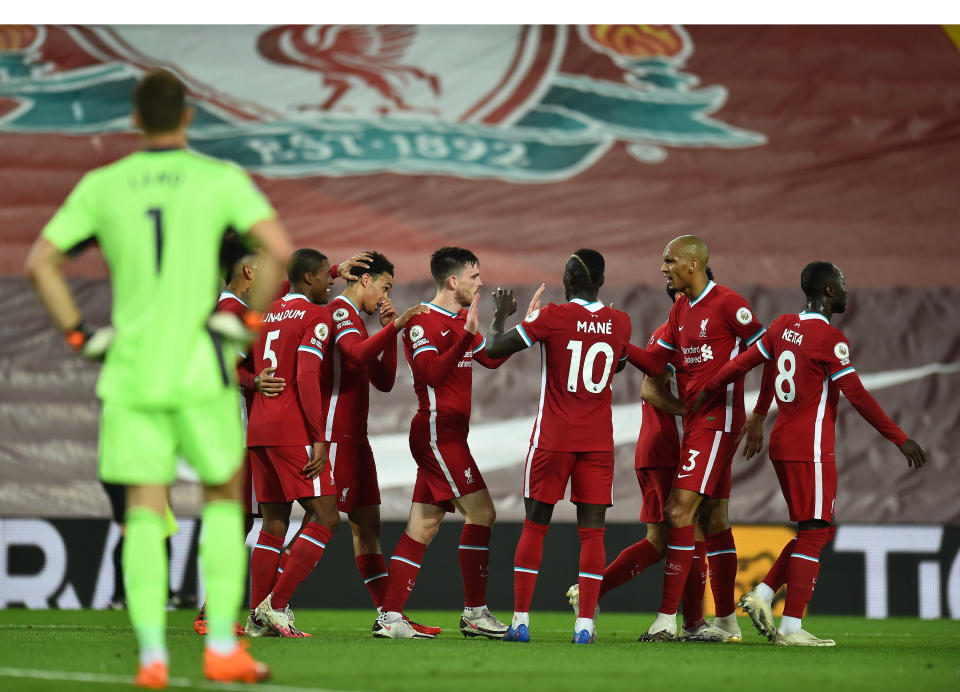 Liverpool players celebrate the go-ahead goal by Andy Robertson (middle) as Arsenal keeper Bernd Leno looks on. (Andrew Powell/Getty Images)