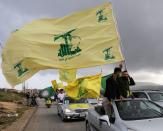 FILE PHOTO: A supporter of Lebanon's Hezbollah gestures as he holds a Hezbollah flag in Marjayoun