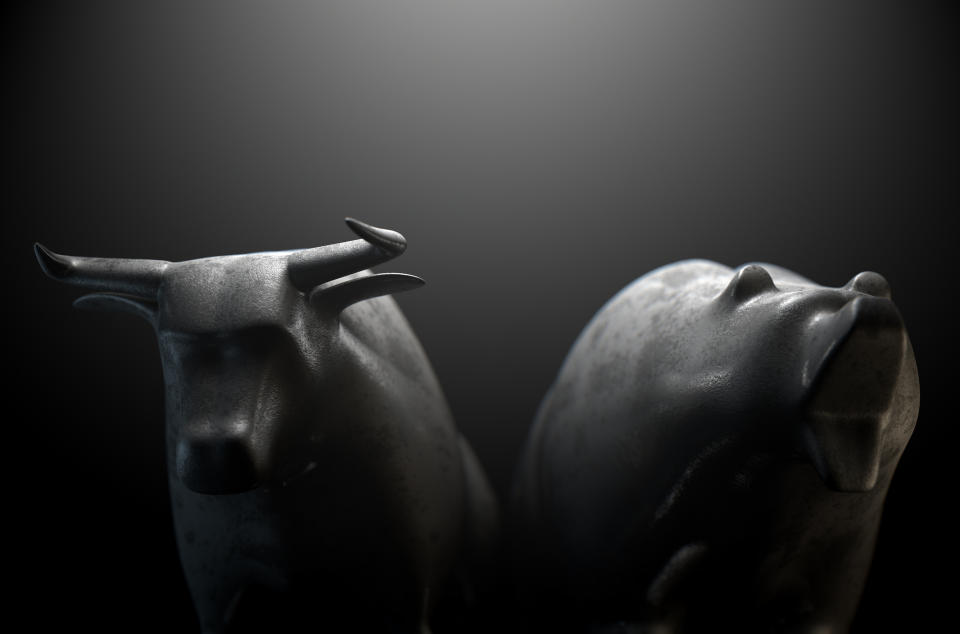 Bull and bear figurines with a dark grey/black background.