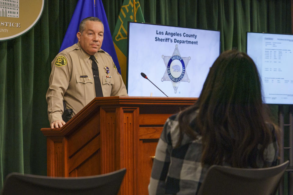 Los Angeles Times reporter Alene Tchekmedyian, foreground, asks Los Angeles County Sheriff Alex Villanueva a question during a news conference, Tuesday, April 26, 2022, in Los Angeles. Villanueva disputed allegations that he orchestrated a coverup of an incident where a deputy knelt on a handcuffed inmate's head last year. Villanueva, who oversees the nation's largest sheriff's department, also indicated that Tchekmedyian is under criminal investigation after she first reported the incident with the inmate. (AP Photo/Damian Dovarganes)