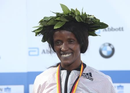 Winner Aberu Kebede of Ethiopia celebrates during the victory ceremony at the Berlin marathon in Berlin, Germany, September 25, 2016. REUTERS/Fabrizio Bensch