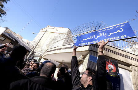 An Iranian protester holds up a street sign with the name of Shi'ite cleric Sheikh Nimr al-Nimr during a demonstration against the execution of Nimr in Saudi Arabia, outside the Saudi Arabian Embassy in Tehran January, 3, 2016. REUTERS/Raheb Homavandi/TIMA