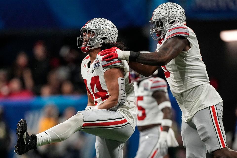 Ohio State defensive end J.T. Tuimoloau (44) and Ohio State defensive end Zach Harrison (9) celebrate stopping Georgia during the second half of the Peach Bowl NCAA college football semifinal playoff game, Saturday, Dec. 31, 2022, in Atlanta.