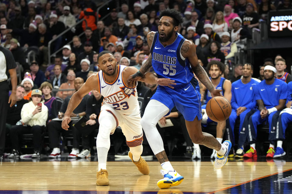 Dallas Mavericks forward Derrick Jones Jr. (55) drives past Phoenix Suns guard Eric Gordon (23) during the first half of an NBA basketball game, Monday, Dec. 25, 2023, in Phoenix. (AP Photo/Rick Scuteri)